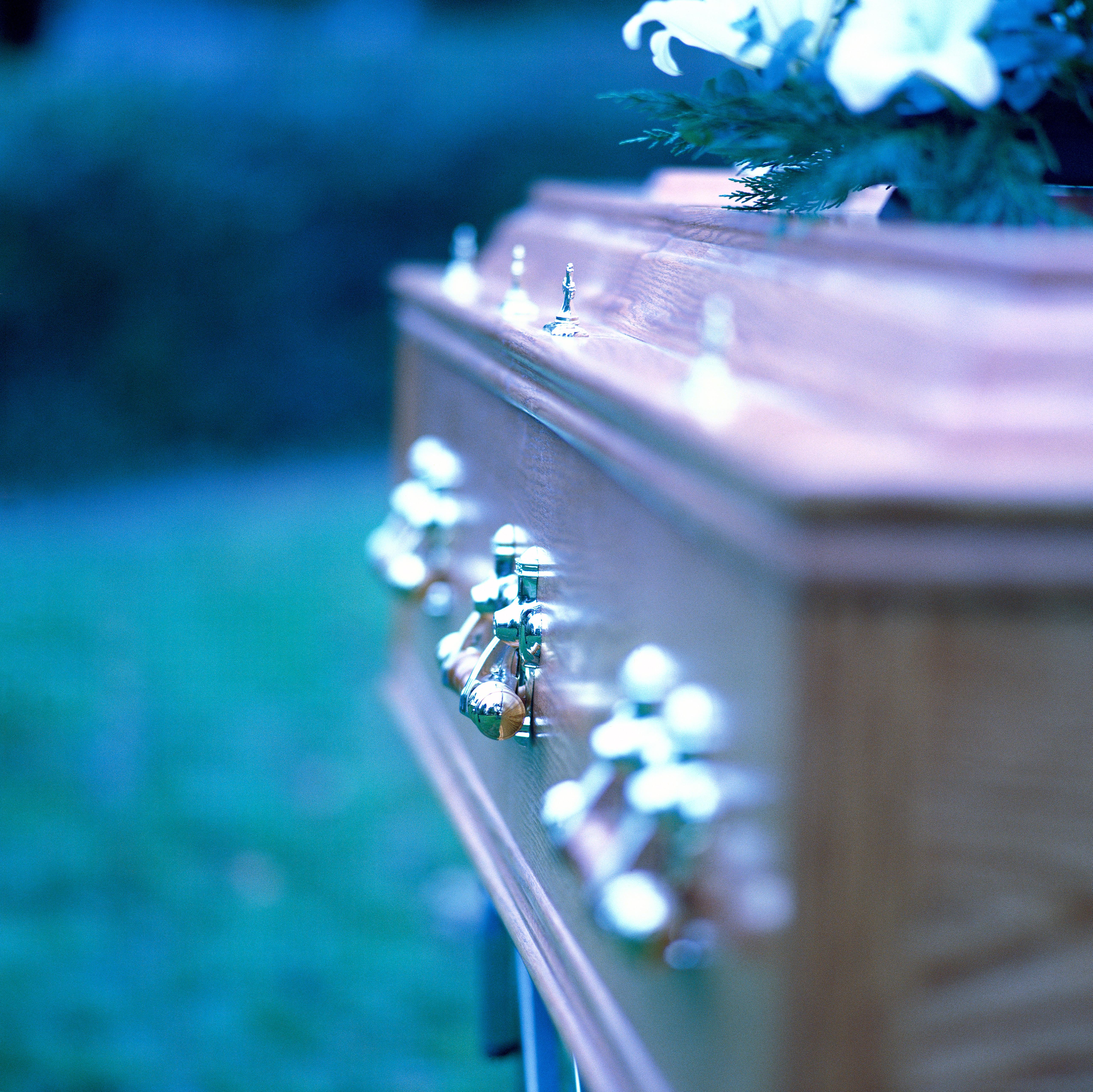 close-up of the side of a coffin with brass handles