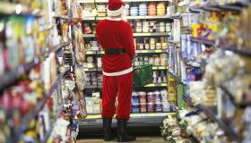 Man dressed as Santa Claus standing in supermarket, rear view