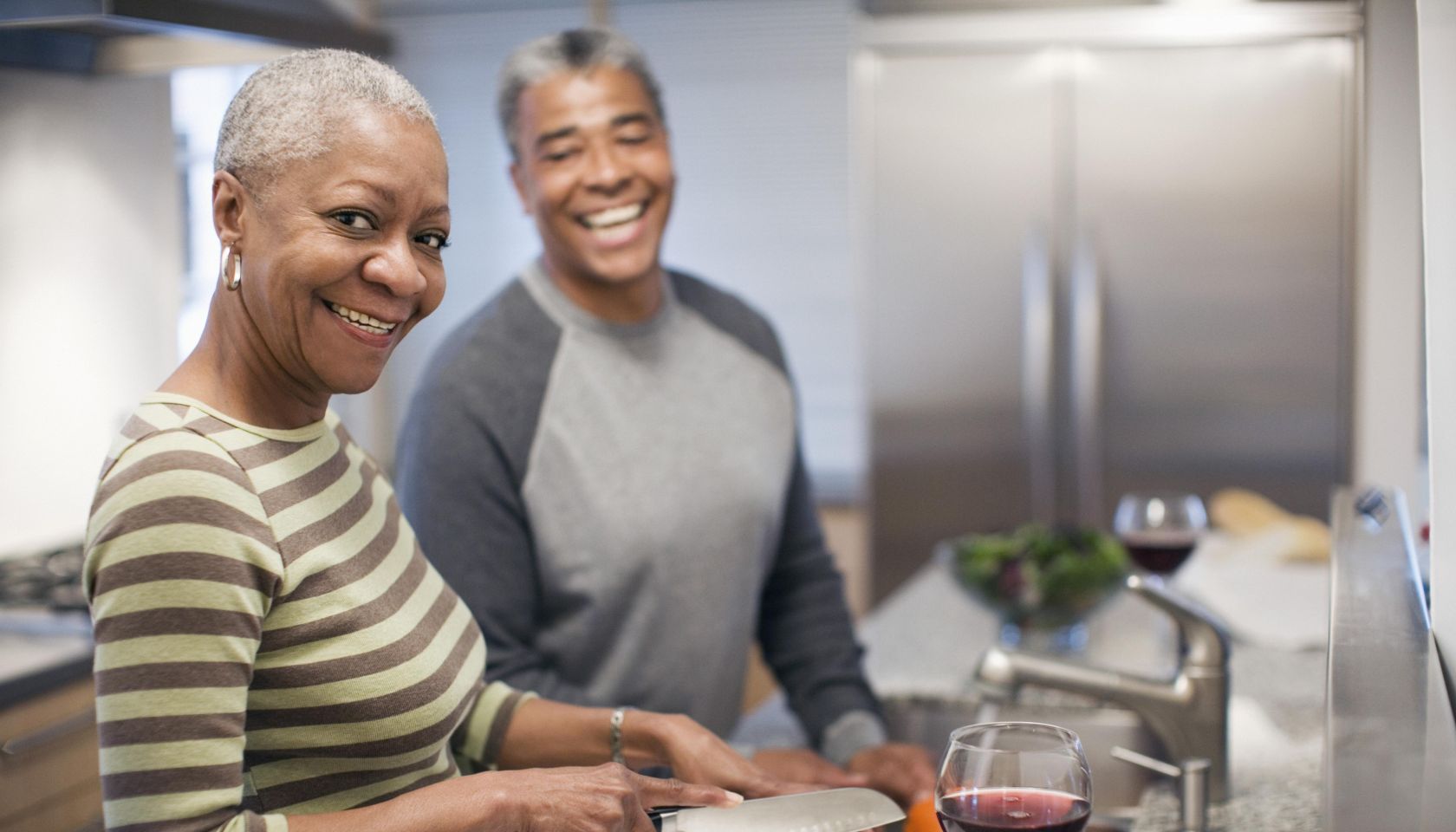 Laughing couple preparing dinner