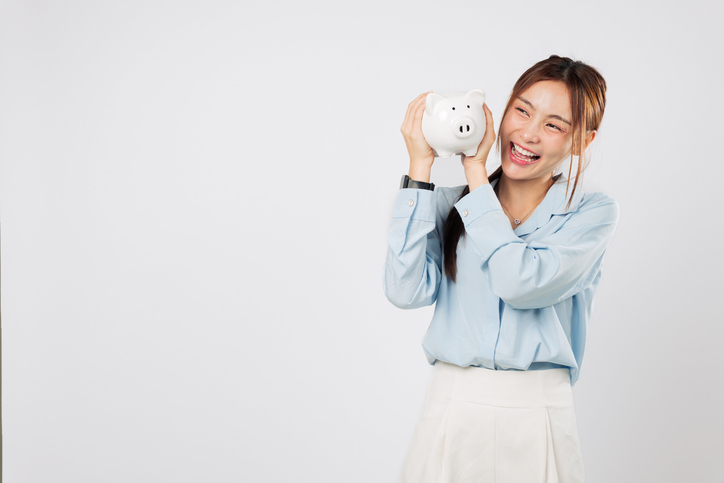 Happy excited Asian woman saving money hugging piggy bank with piggy dream smile