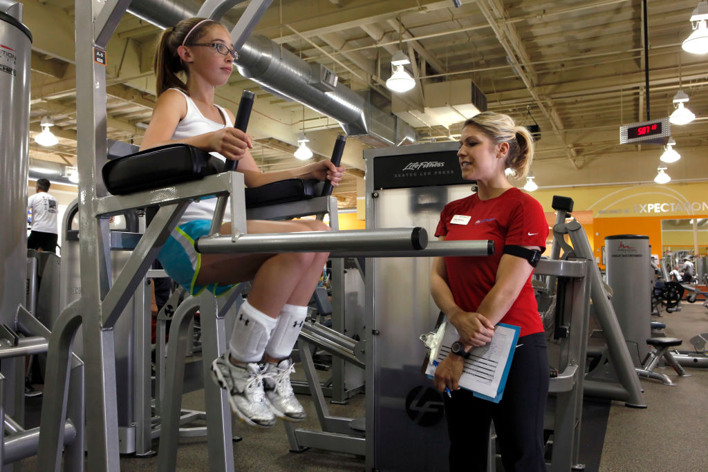 Trainer Terri Whitmore instructs teenager Maddie McPhail in the proper way to lift and do strength training at 24 Hour Fitness in Rheem, Calif., on Tuesday, May 4, 2010. A new study shows that injuries among teen girl weight lifters has shot up 143% betwe