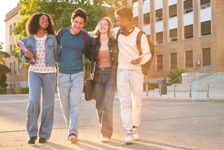 Diverse students walking on campus during golden hour