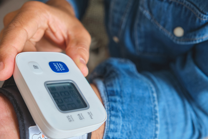 Person checking blood pressure using a digital tonometer
