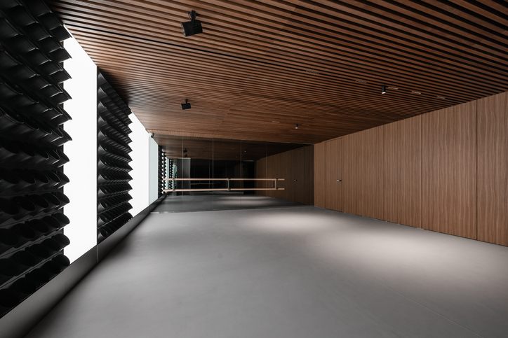 Modern dance studio room with wood slatted ceiling.