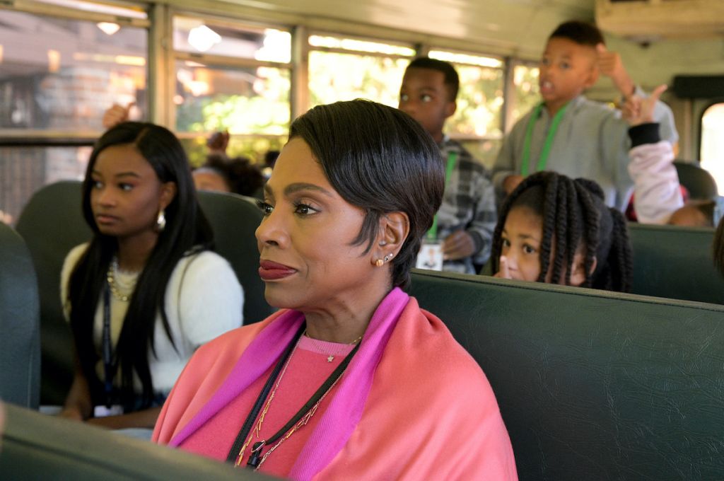 A group of people, including a woman in a pink top, sitting on a bus.