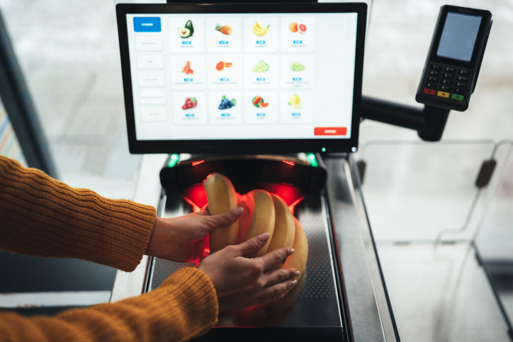 Customer using self-checkout in modern grocery store