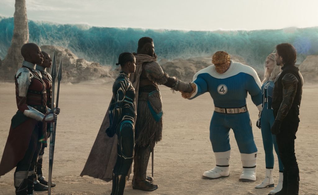 A group of superheroes, including the Dora Milaje, Shuri, M'Baku, The Thing, Invisible Woman, Winter Soldier, Falcon, and Ghost, stand together in a desert landscape.